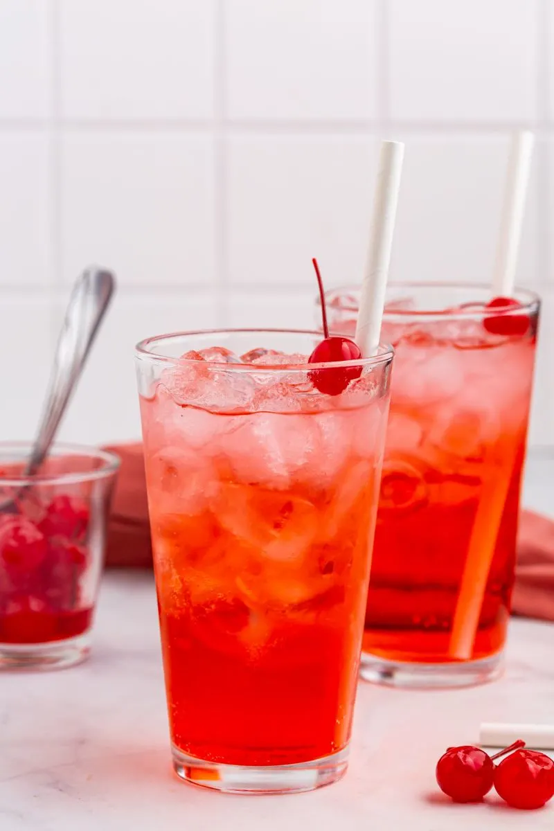 shirley temples in two glasses with cherry and straws