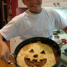 recipeboy holding jack o lantern sloppy joe pie in a skillet