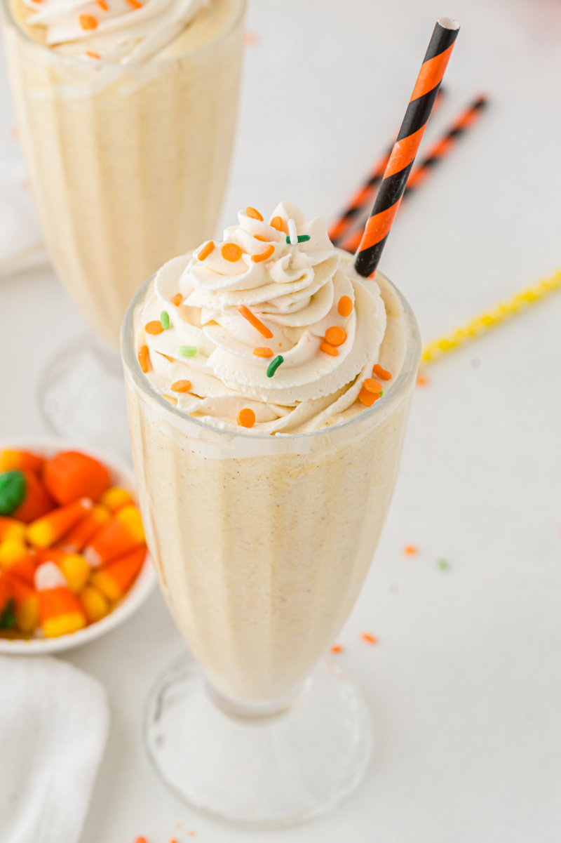 pumpkin pie milkshake in a glass with a straw