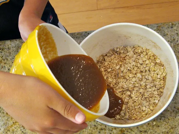 making Pumpkin Granola pouring liquid to add to oats