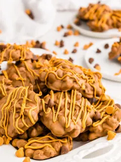 chocolate butterscotch peanut clusters stacked on white plate