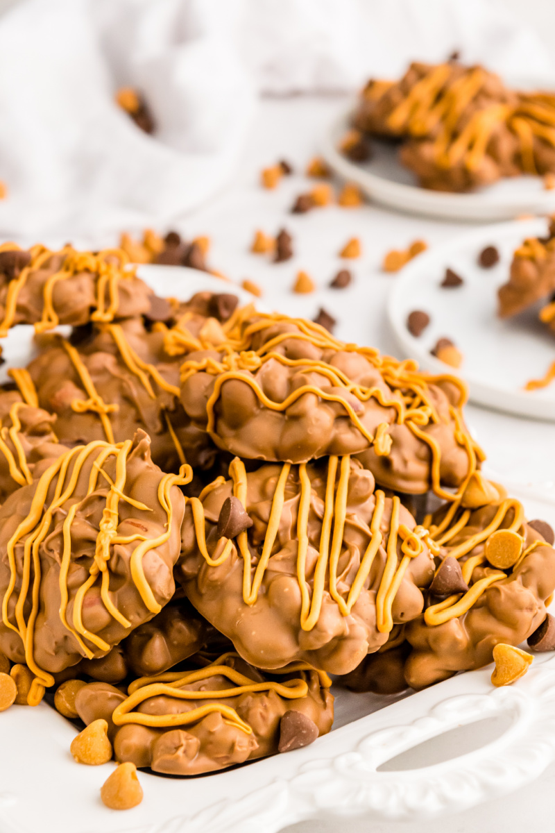 chocolate butterscotch peanut clusters stacked on white plate