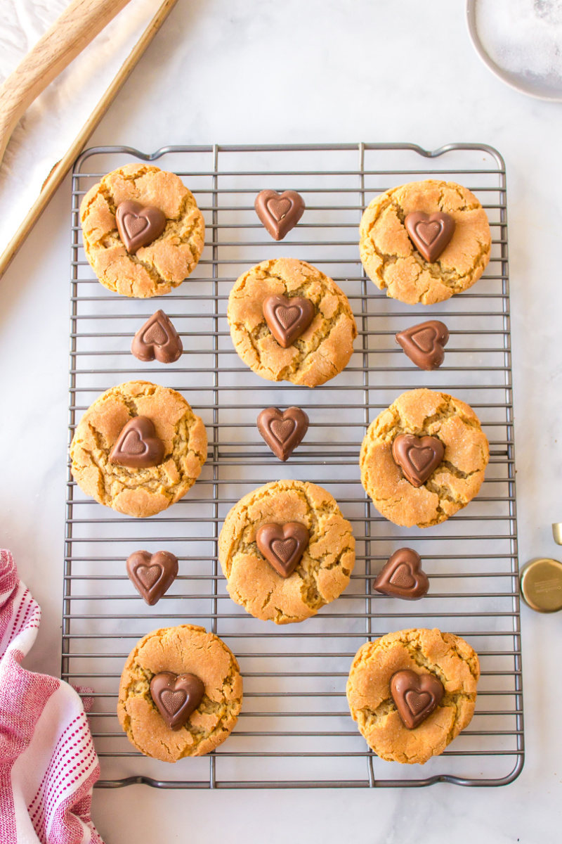chocolate heart peanut butter cookies on a baking sheet with chocolates