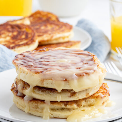 stack of maple cinnamon roll pancakes topped with icing