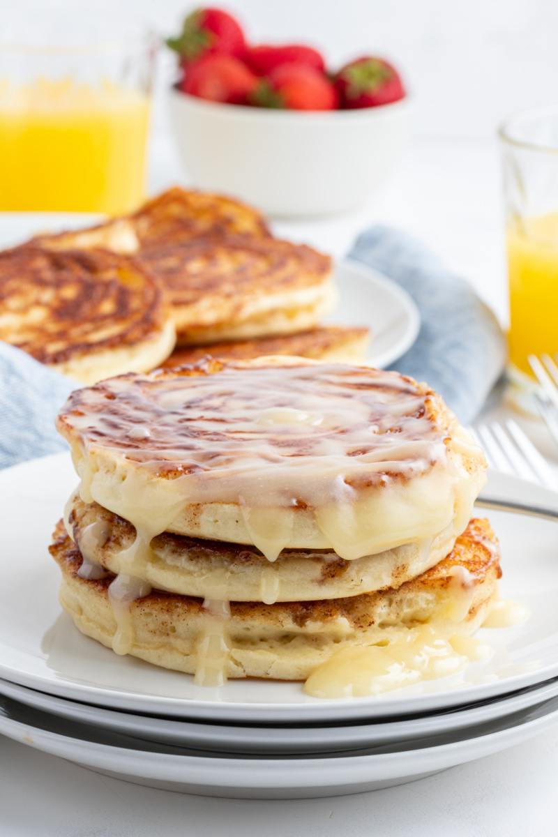 stack of maple cinnamon roll pancakes topped with icing