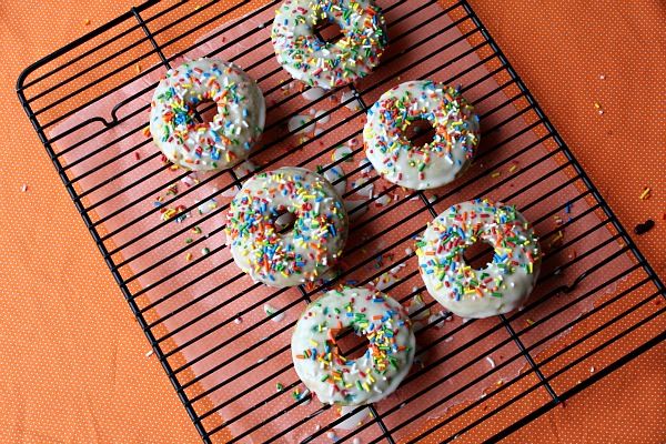 Cake Batter Doughnuts topped with vanilla glaze and sprinkles