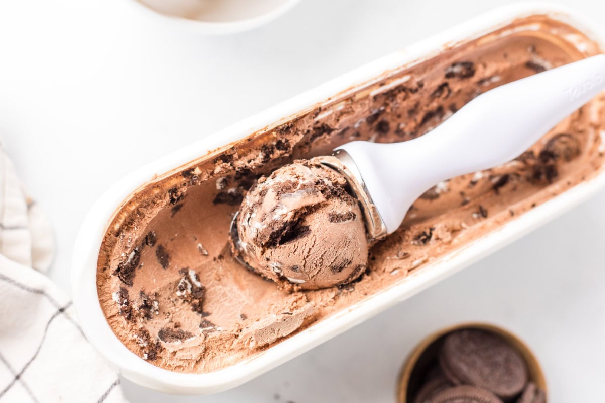 Chocolate cookies and cream ice cream made with a rich cocoa base and loaded with Oreo cookies. Creamy, indulgent and so good! ice cream scoop in tub of ice cream