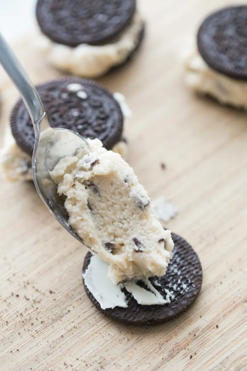 making chocolate chip cookie dough stuffed oreos by adding some of the cookie dough in between the chocolate cookies