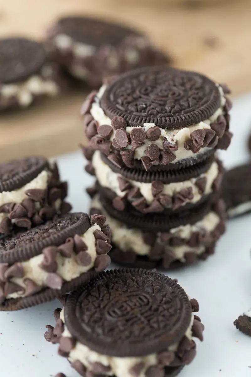 chocolate chip cookie dough stuffed oreos stacked on a white platteer