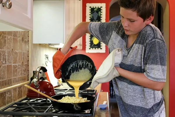 recipeboy pouring cheese sauce into skillet