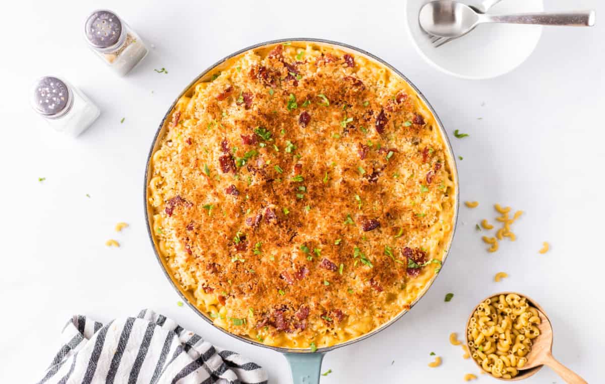 Recipe for Skillet Macaroni and Cheese is super cheesy, topped with bread crumbs, bacon and more cheese and baked until bubbly. skillet filled with macaroni and cheese