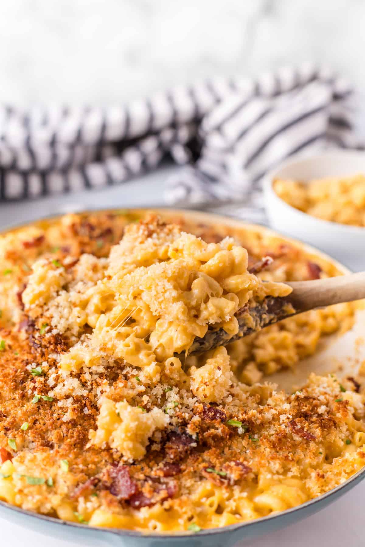 Recipe for Skillet Macaroni and Cheese is super cheesy, topped with bread crumbs, bacon and more cheese and baked until bubbly. skillet macaroni and cheese with spoon
