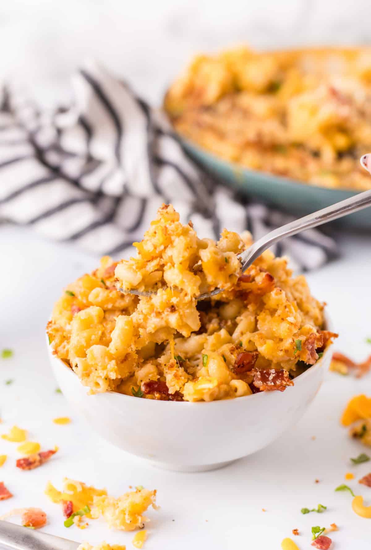 Recipe for Skillet Macaroni and Cheese is super cheesy, topped with bread crumbs, bacon and more cheese and baked until bubbly. serving of skillet macaroni and cheese in bowl