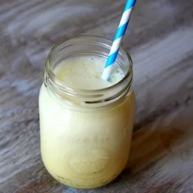 jar of orange julius with a blue and white paper straw