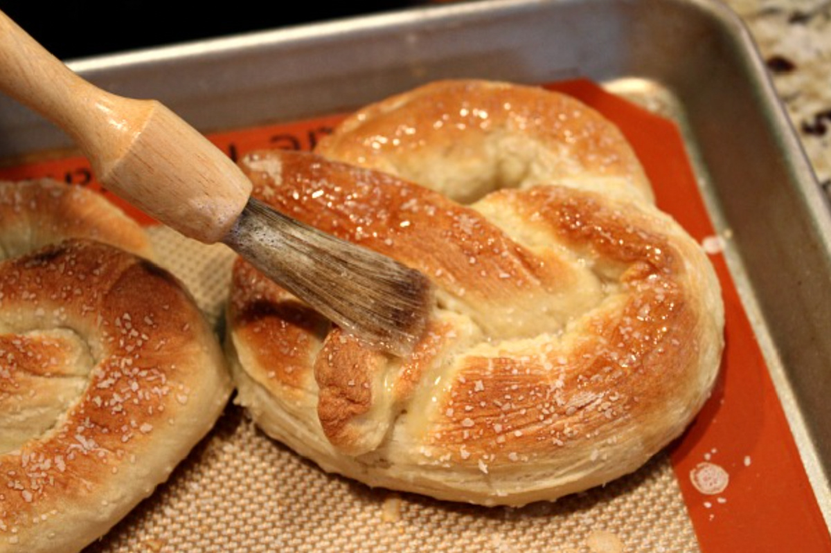 brushing butter onto hot pretzels