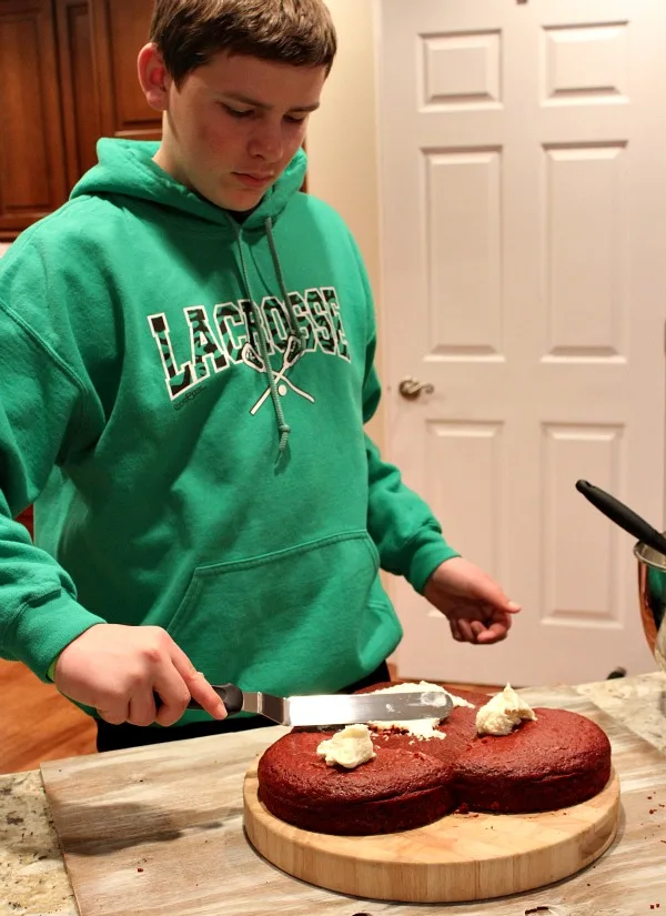 RecipeBoy frosting a heart shaped cake