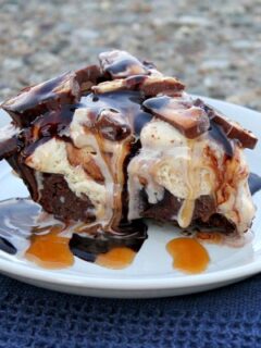 slice of snickers ice cream brownie pie on a white plate