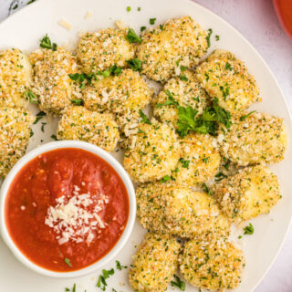 baked mozzarella bites with a dish of dipping sauce