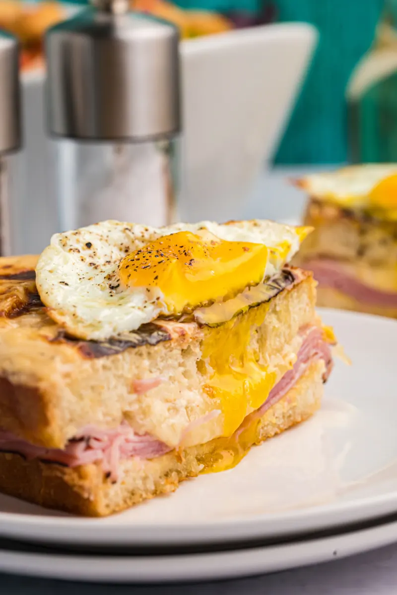 croque madame halves stacked with broken egg on top
