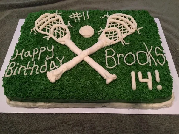 Lacrosse Birthday Cake with green grass frosting and white lacrosse sticks