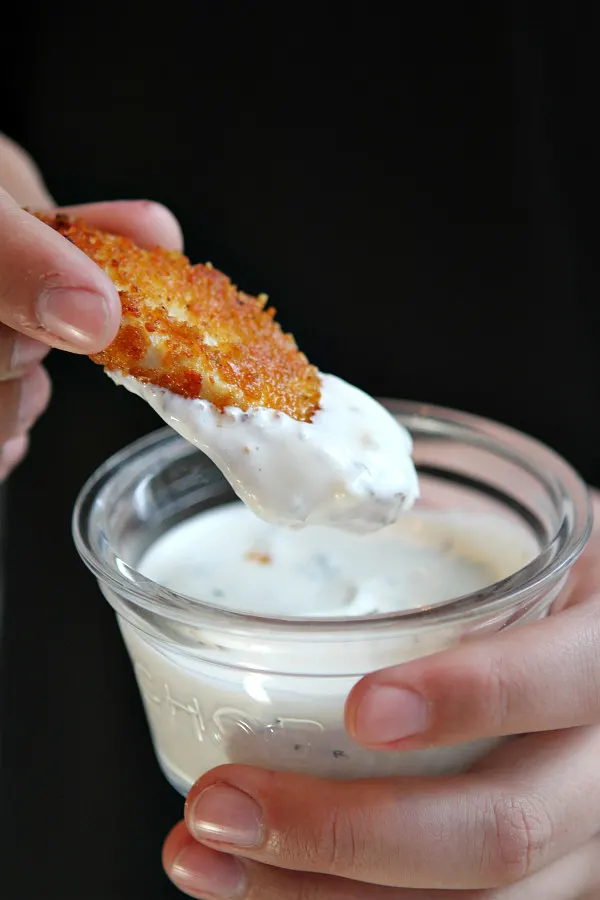 Dipping a chicken finger in ranch dressing