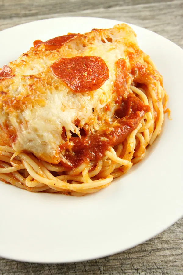 serving of chicken pizzaiola on top of pasta in a white serving dish