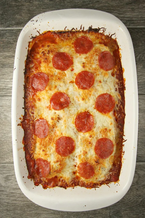 overhead shot of chicken pizzaiola with pepperoni on top in a white casserole dish