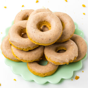 baked pumpkin donuts stacked on a green platter