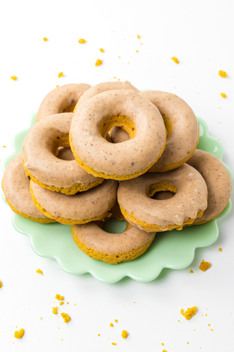 baked pumpkin donuts stacked on a green platter