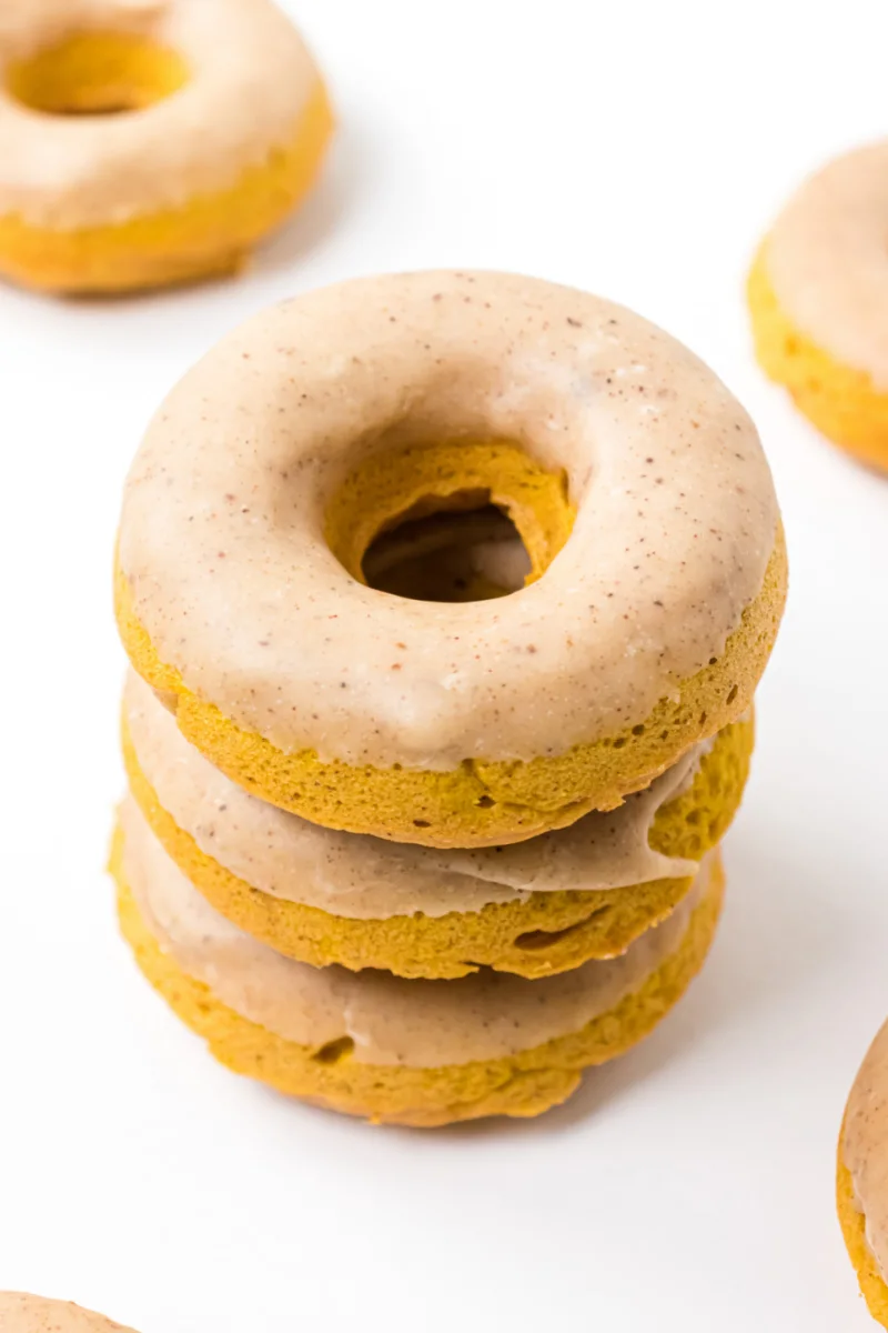 three baked pumpkin donuts stacked