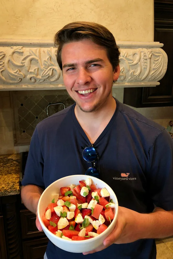 RecipeBoy holding his watermelon strawberry caprese salad