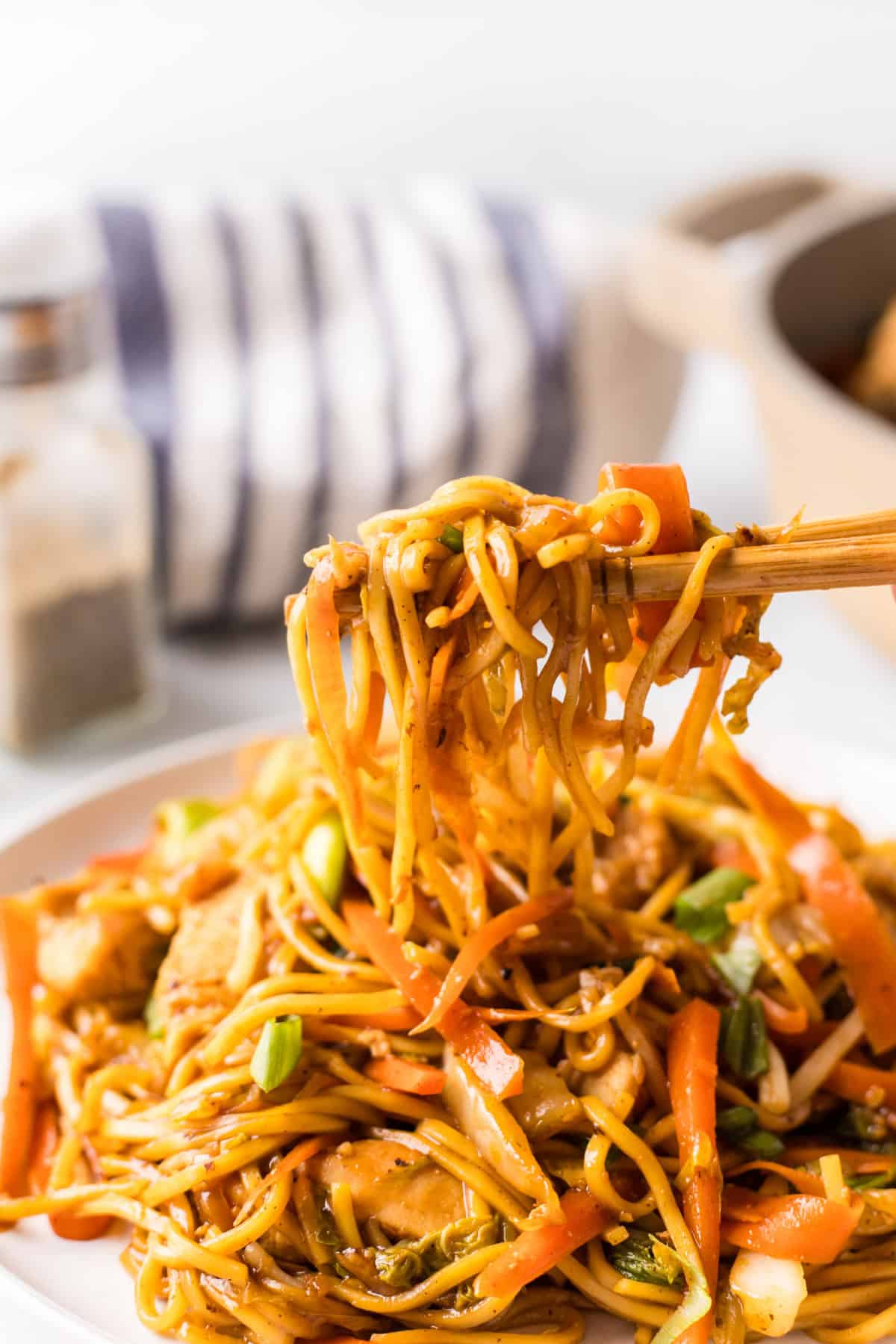 Super easy, family friendly dinner recipe! Recipe from RecipeBoy.com. chopsticks holding up chicken chow mein from plate