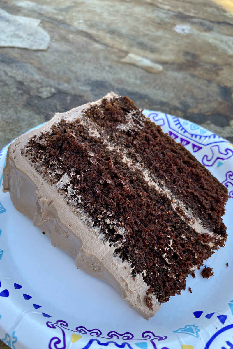 slice of chocolate cake sitting on a paper plate