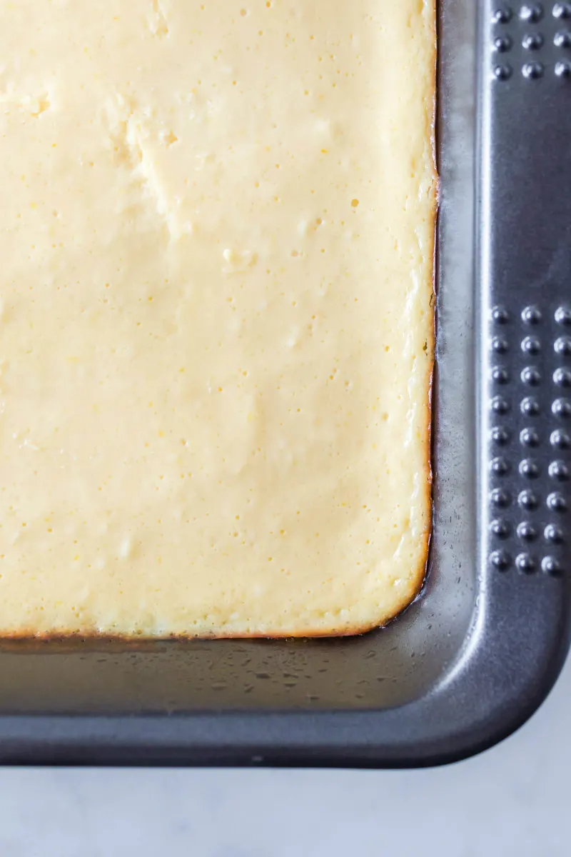 baked key lime bars baked in a metal pan overhead shot of a corner of the pan