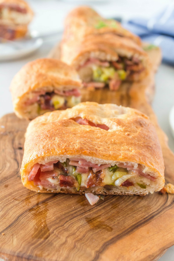 ham and swiss stromboli cut into pieces on a cutting board