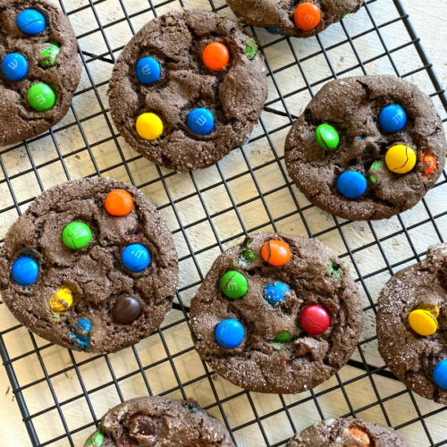 overhead shot of chocolate cake mix m&m cookies cooling on a cooling rack