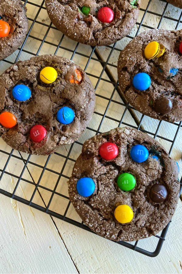 overhead shot of chocolate cake mix m&m cookies cooling on a cooling rack