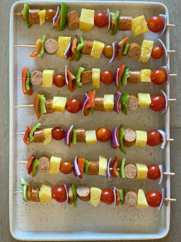 hawaiian chicken sausage kabobs on a sheet pan ready for the grill