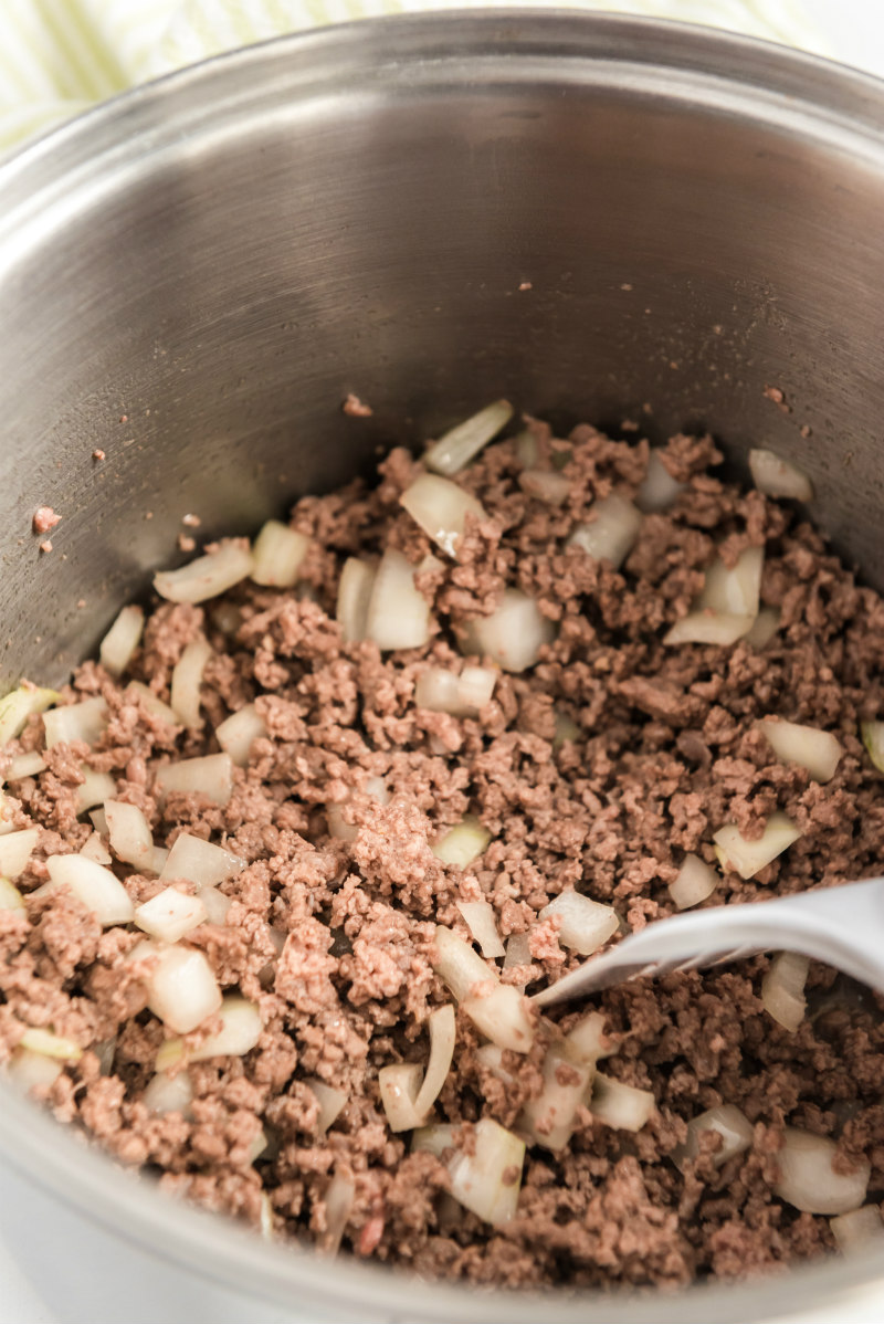 ground beef and onion being cooked in a pot