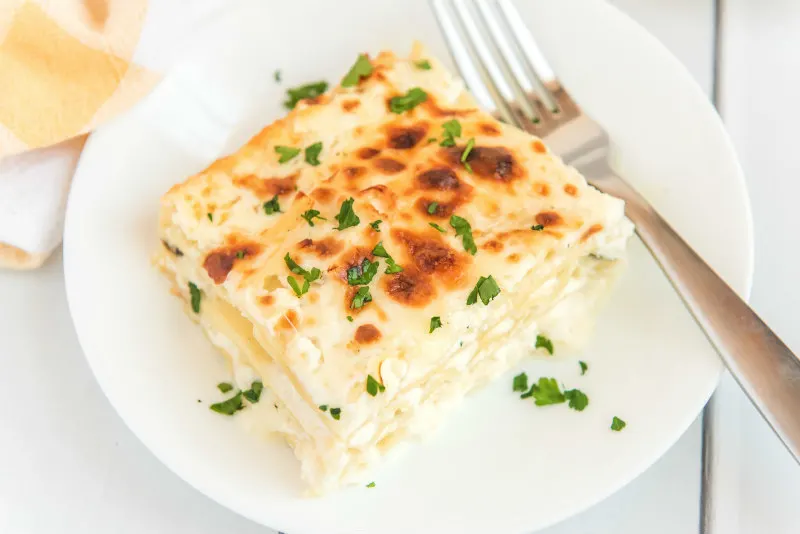 slice of white chicken lasagna on a white plate