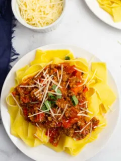 pappardelle bolognese on a white plate