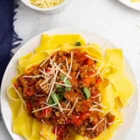 pappardelle bolognese on a white plate