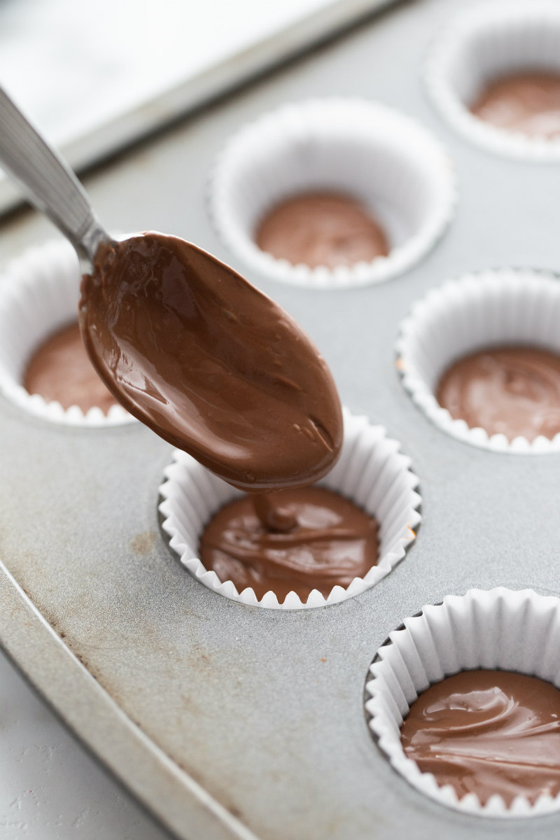 making peanut butter cups in muffin tin- adding melted chocolate