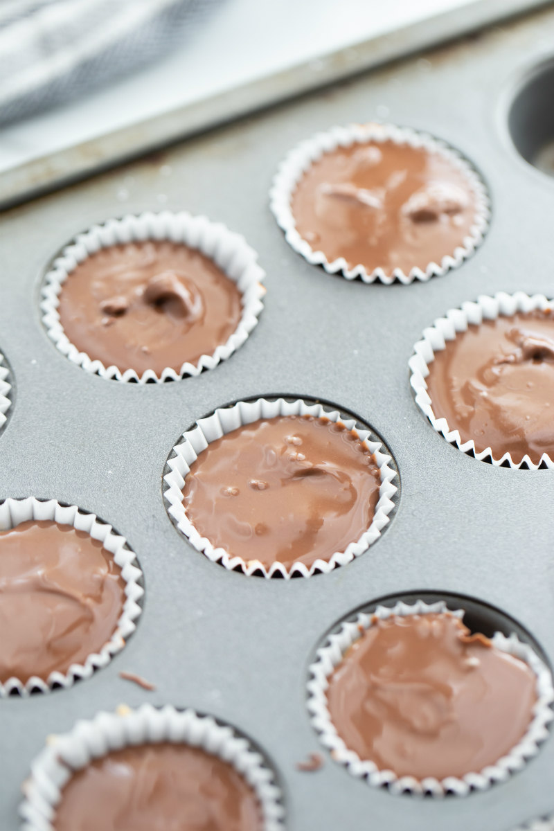 peanut butter cups being made in muffin tin ready for setting