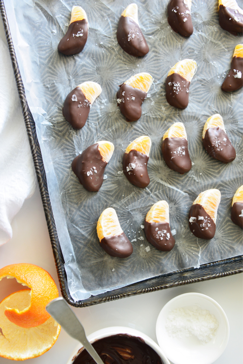 orange segments dipped in chocolate and set on baking sheet