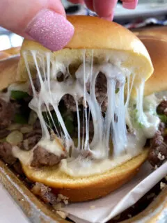 pulling apart a cheesy Philly Cheese Steak Slider
