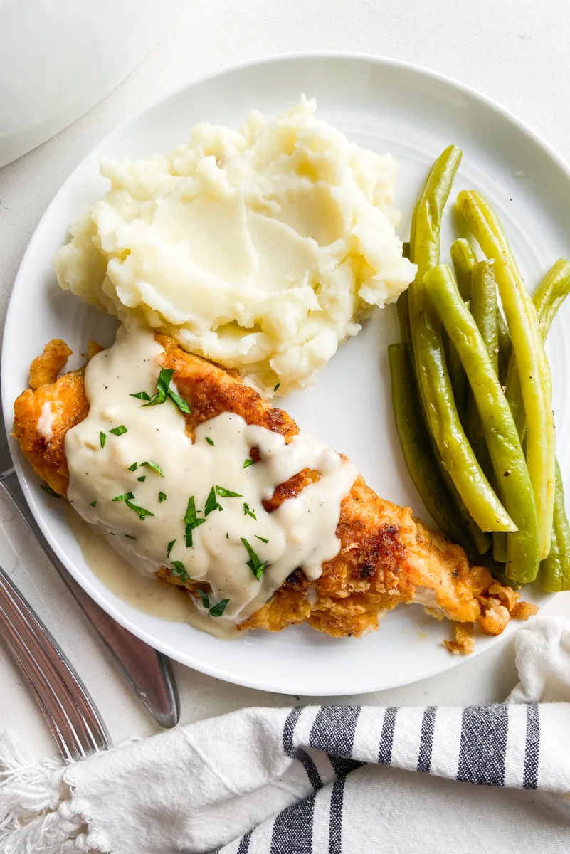 chicken fried chicken plated with potatoes and green beans