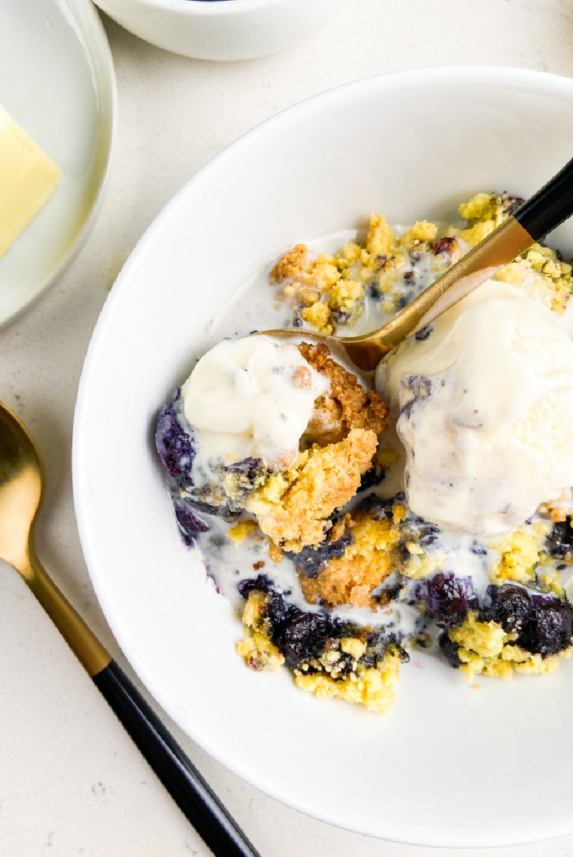 blueberry cobbler in white bowl with ice cream