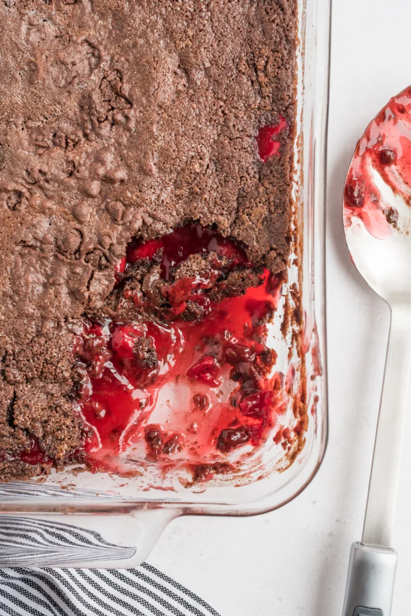 chocolate cherry dump cake in dish with scoop taken out of it