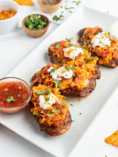 salsa chicken breasts on white platter with bowl of salsa